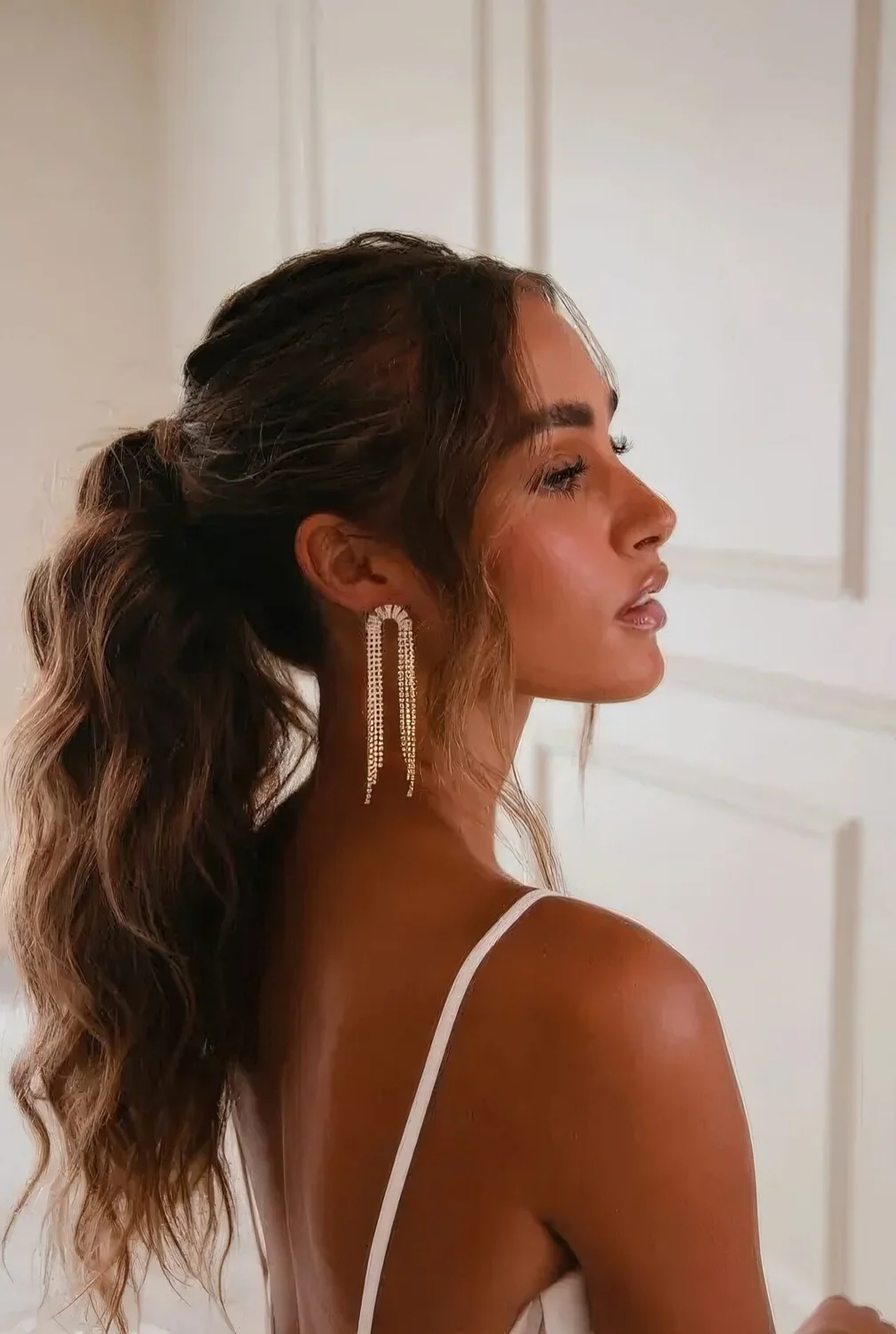 Wavy volumetric ponytail with a wavy top and wavy face-framing hair.