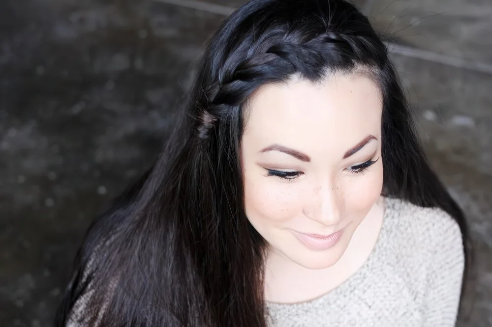 French-braided dark headband with loose lengths.