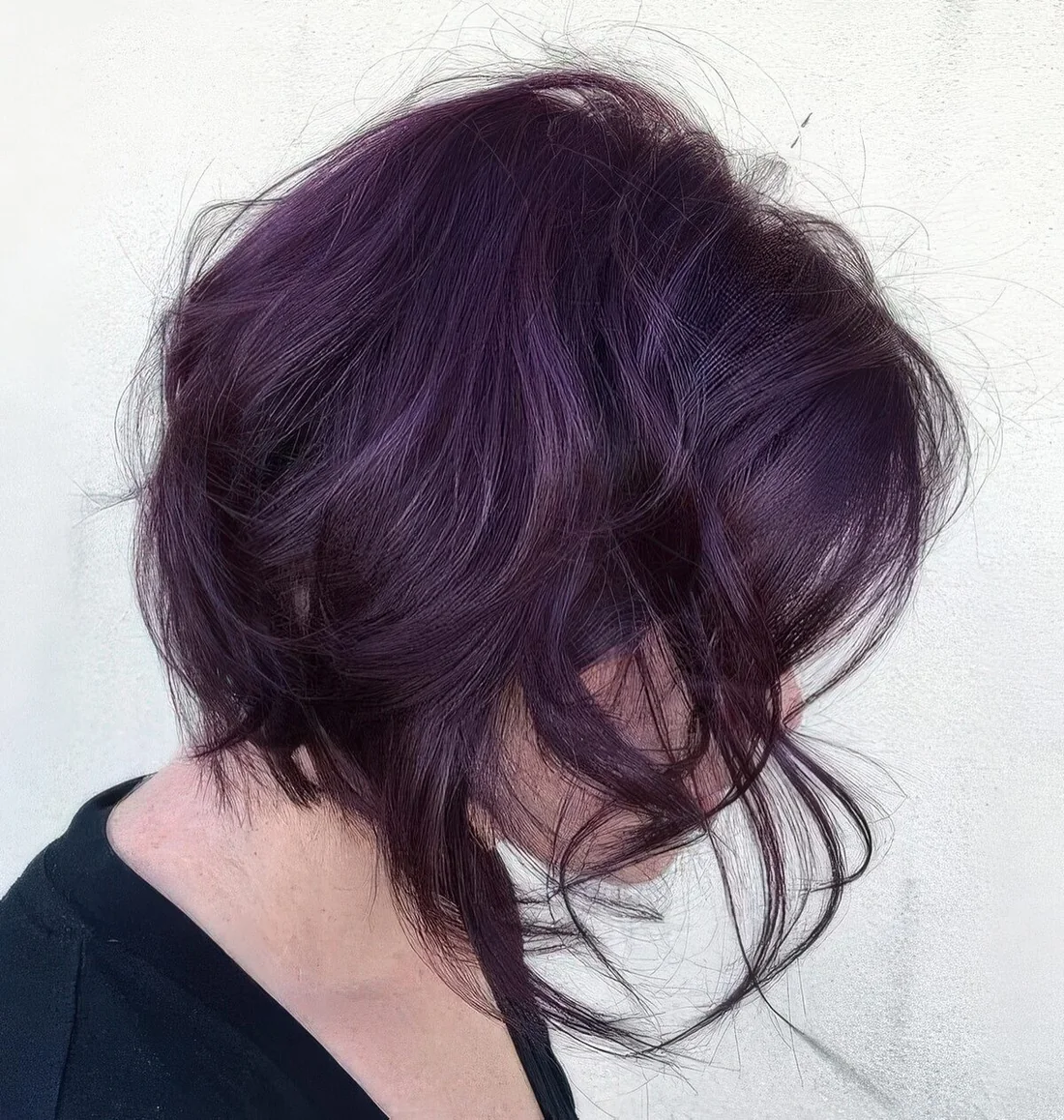 Deep purple messy textured wavy long bob with a lot of volume.