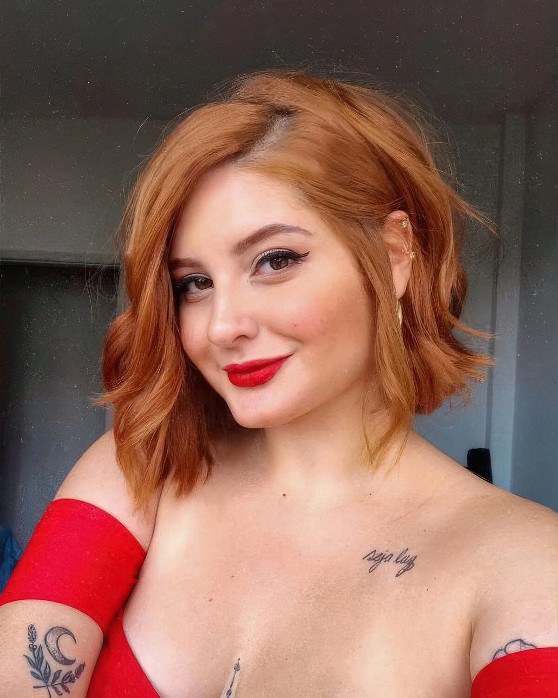 Angled copper red bob with a bit of waves, messy side part.