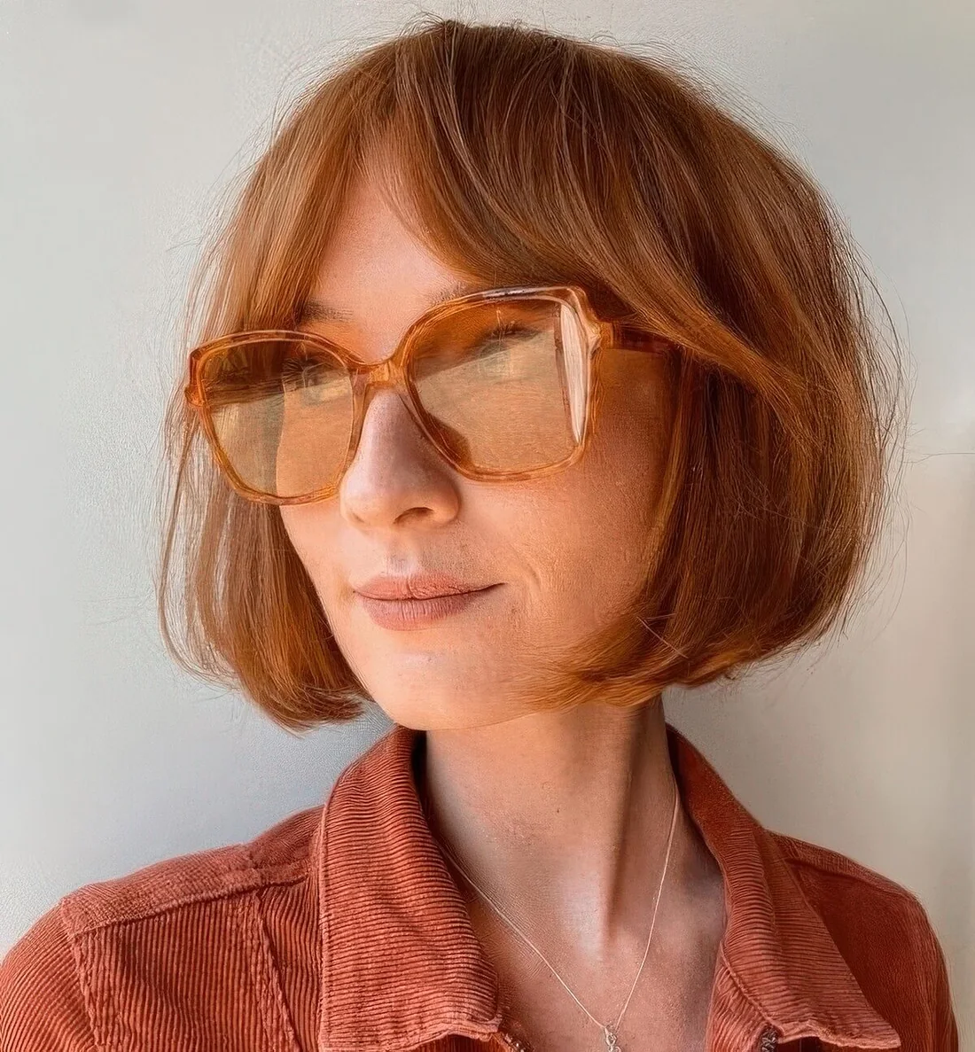 Short red bob with bottleneck bangs.