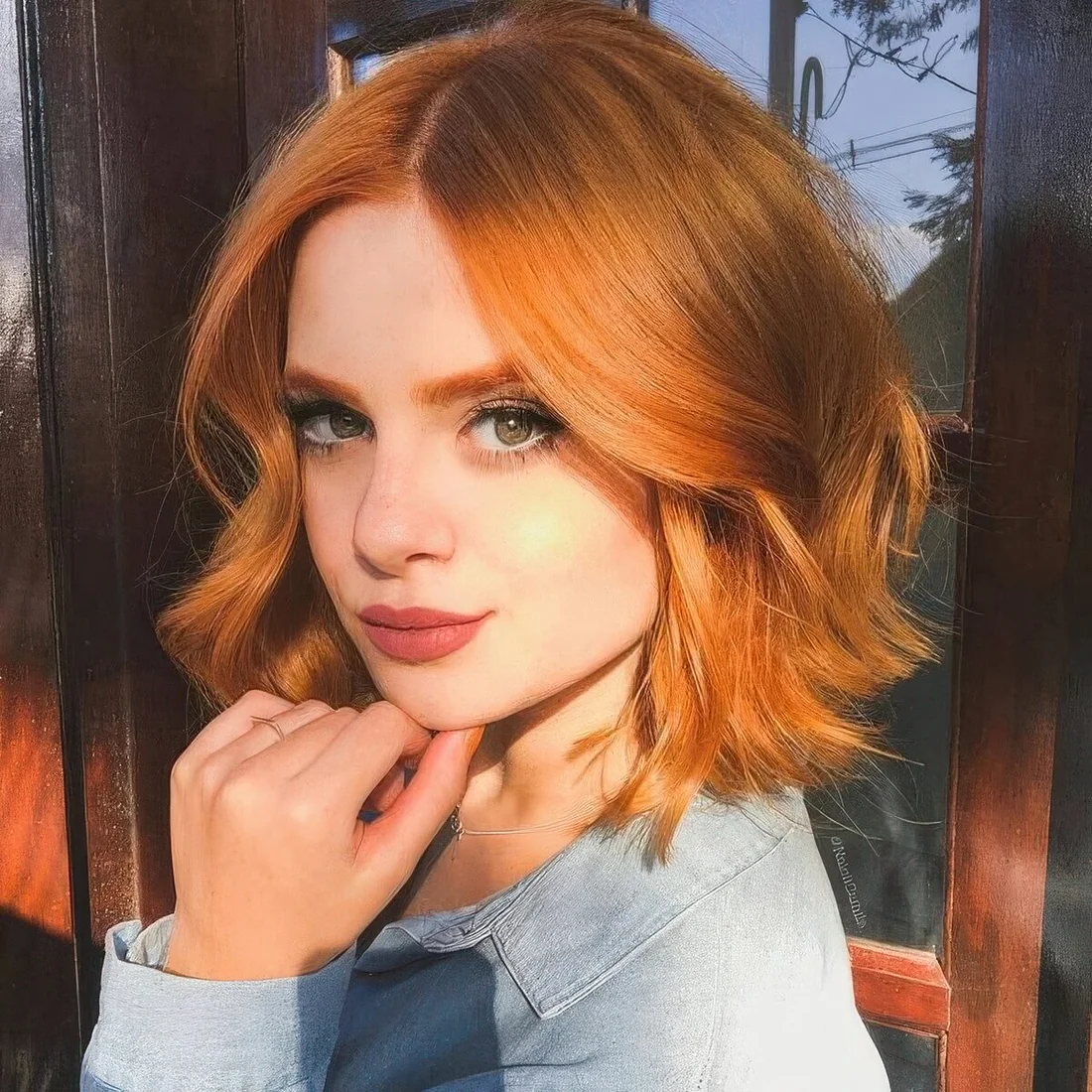 Copper red wavy long bob with face-framing layers.
