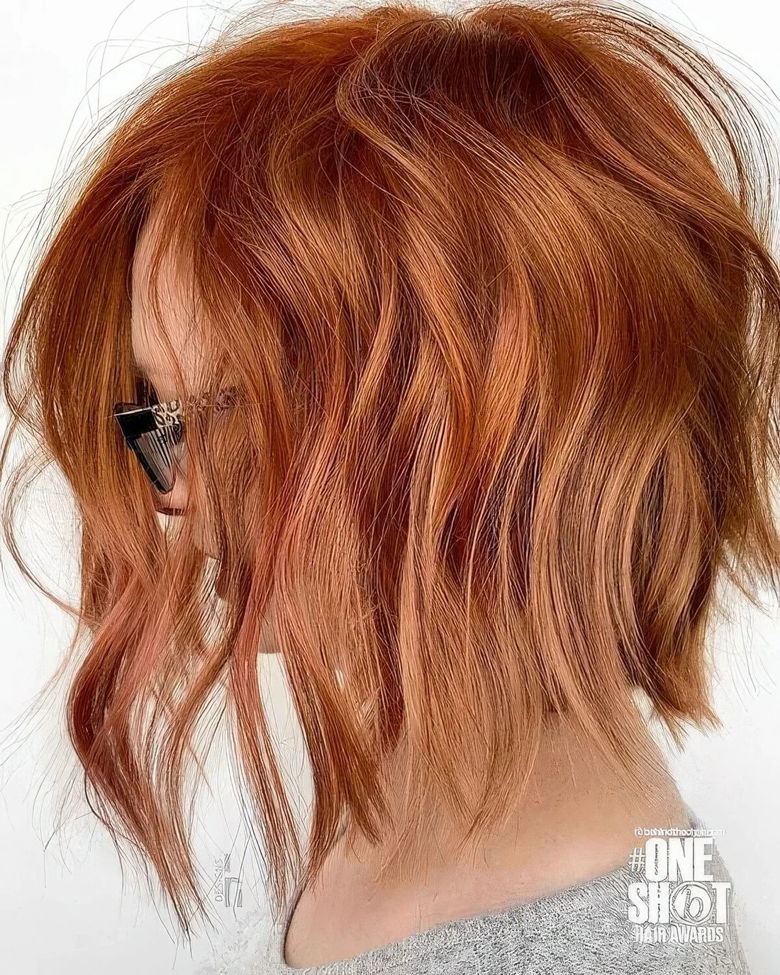 Copper red inverted long bob with a lot of dimension and waves.