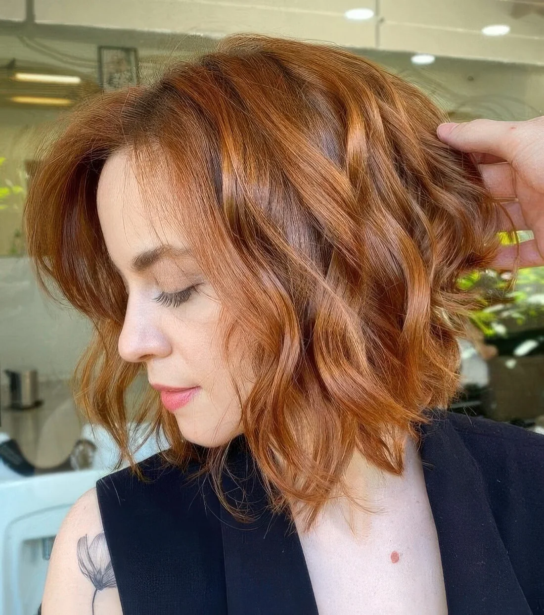 Photo showing copper red wavy bob with volume, with the hairstyle clearly visible.