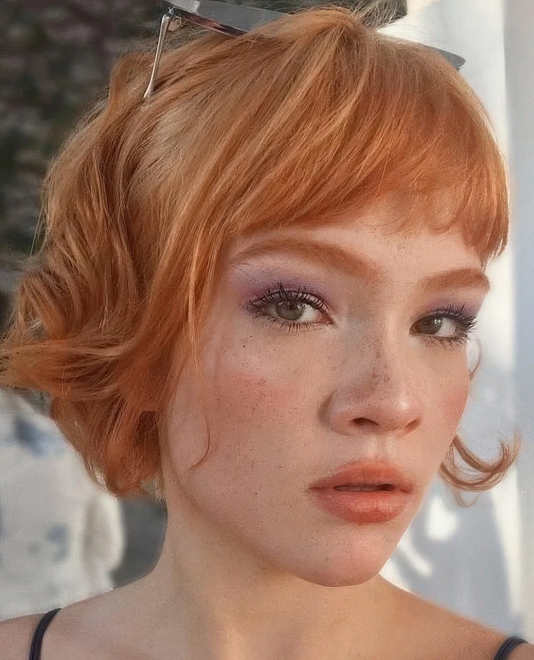 Ginger red jaw-length bob with layered bangs and waves.