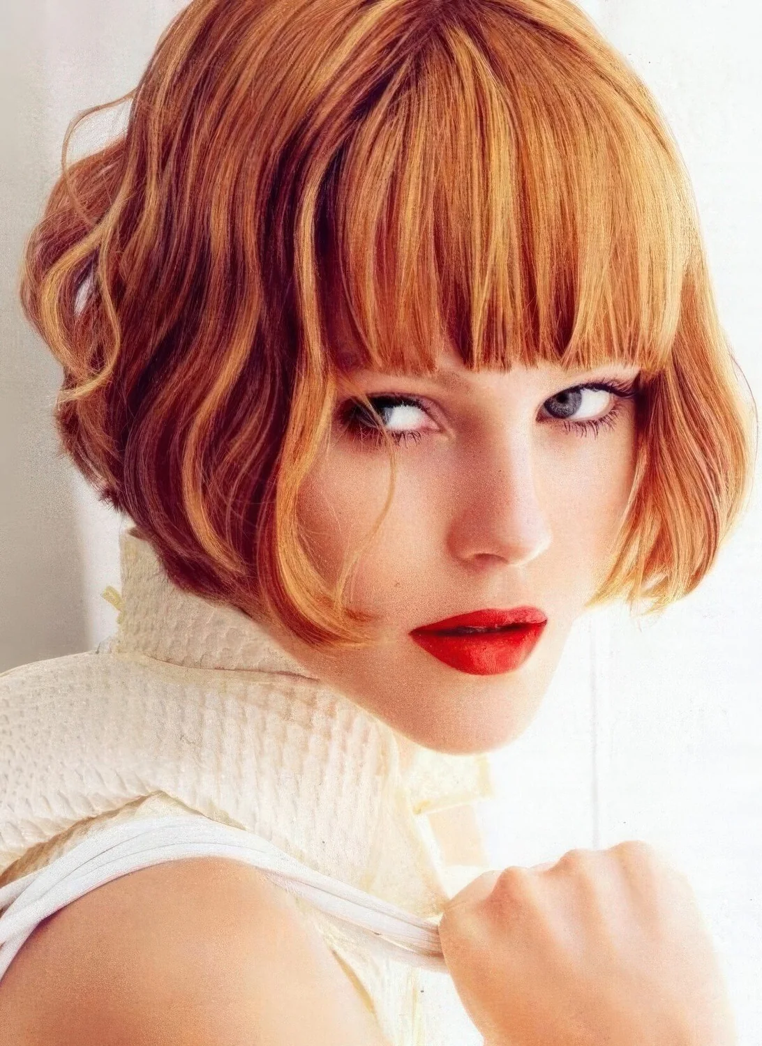 Ginger red ear-length bob with a thick classic fringe and waves.