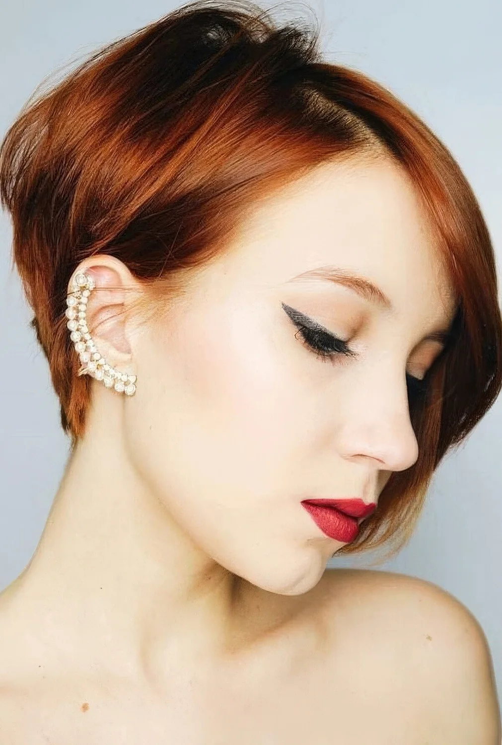 Ginger red ear-length bob with side part and volume.