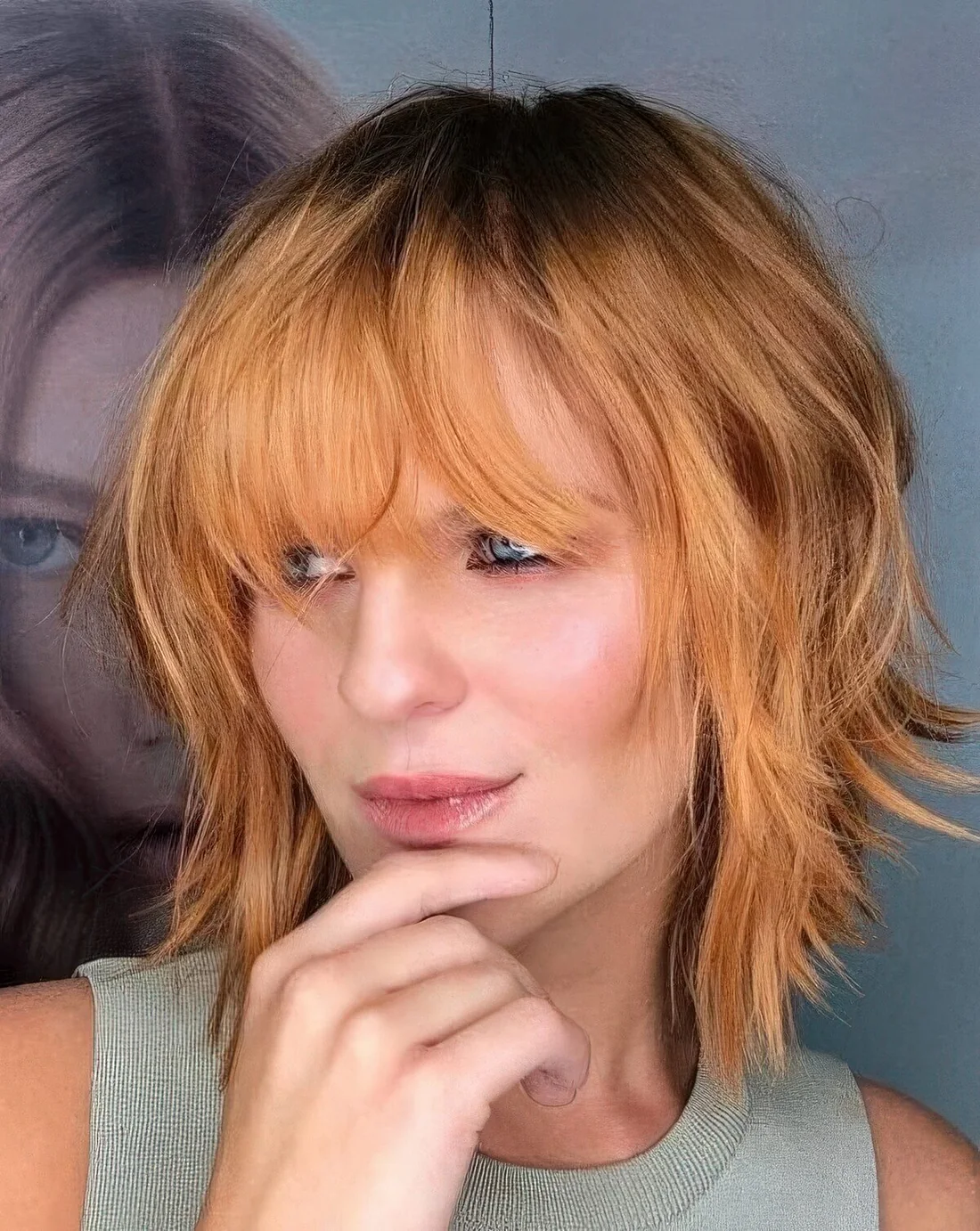 Ginger shaggy medium bob with a darker root and a fringe.