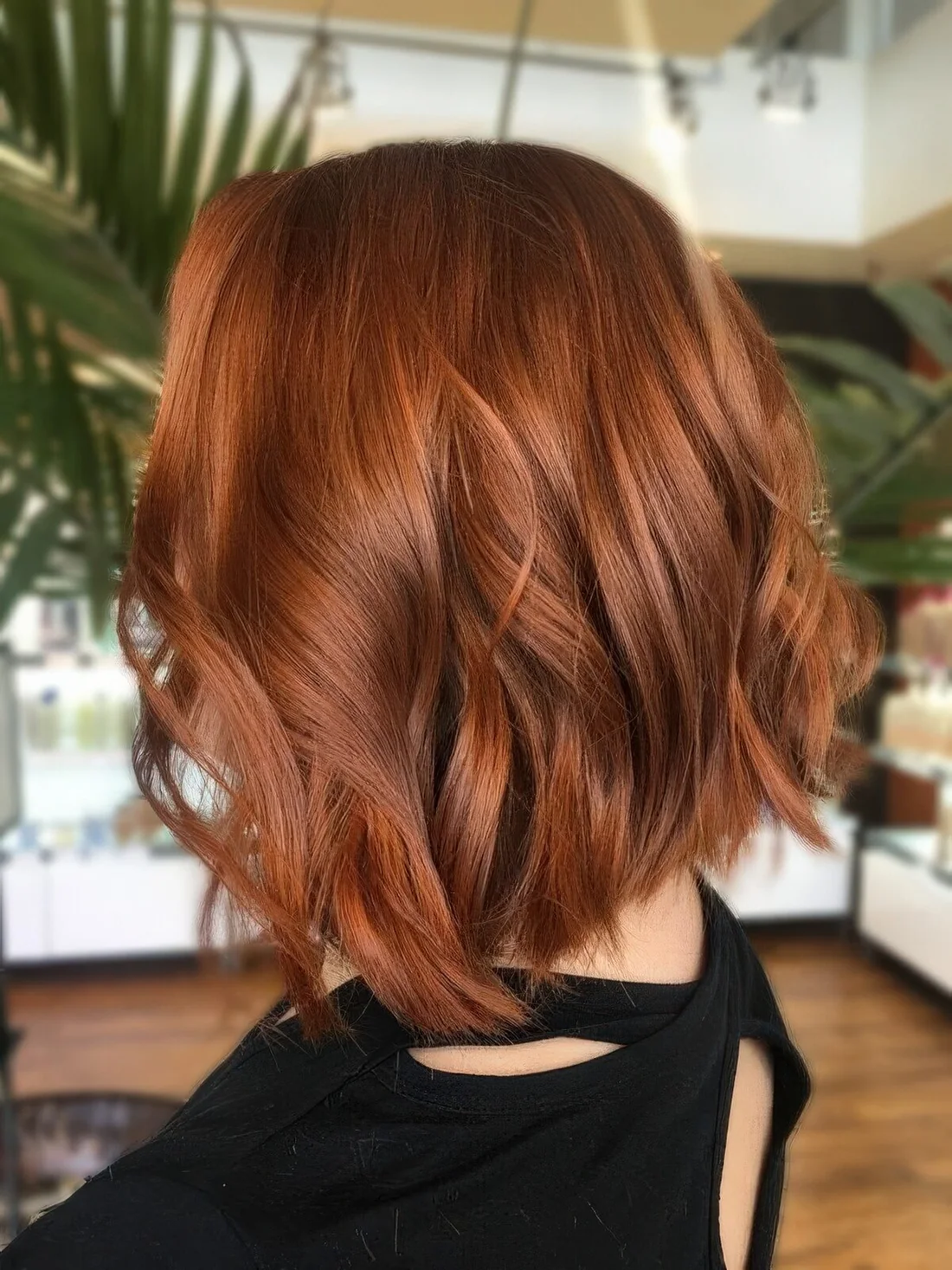 Photo showing long copper red wavy bob, with the hairstyle clearly visible.