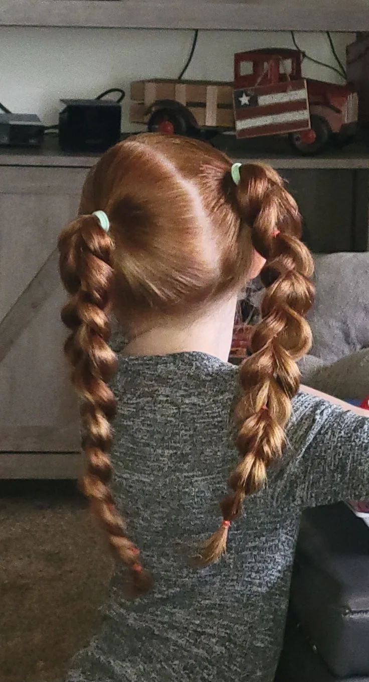 Twin pull-through braids with full sections for an active school hairstyle