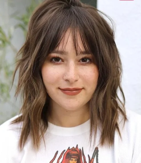 Shaggy edgy midi cut with choppy layers, with crisp bangs to softly frame the face and for a dramatic look.