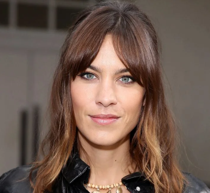 Alexa Chung with midlength curtain bangs and long highlighted layers, she accentuates the shag look even more with her hair pulled back at the sides.