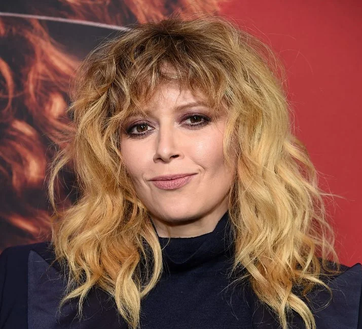 Natasha Lyonne's go to cut has those signature layers all over and wispy, curly moon bangs.