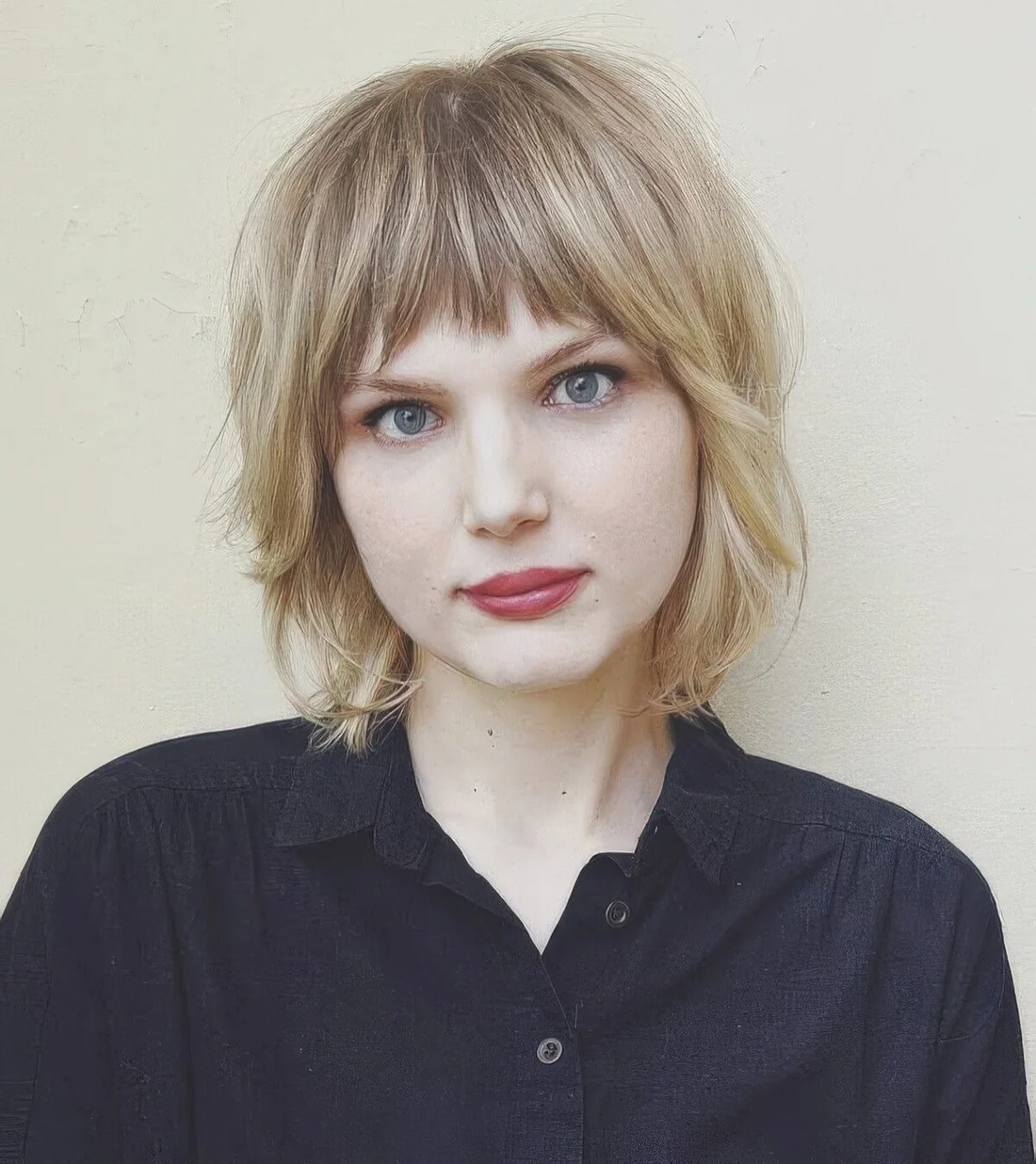 Blonde shaggy chin-length bob with a fringe and face-framing layers.