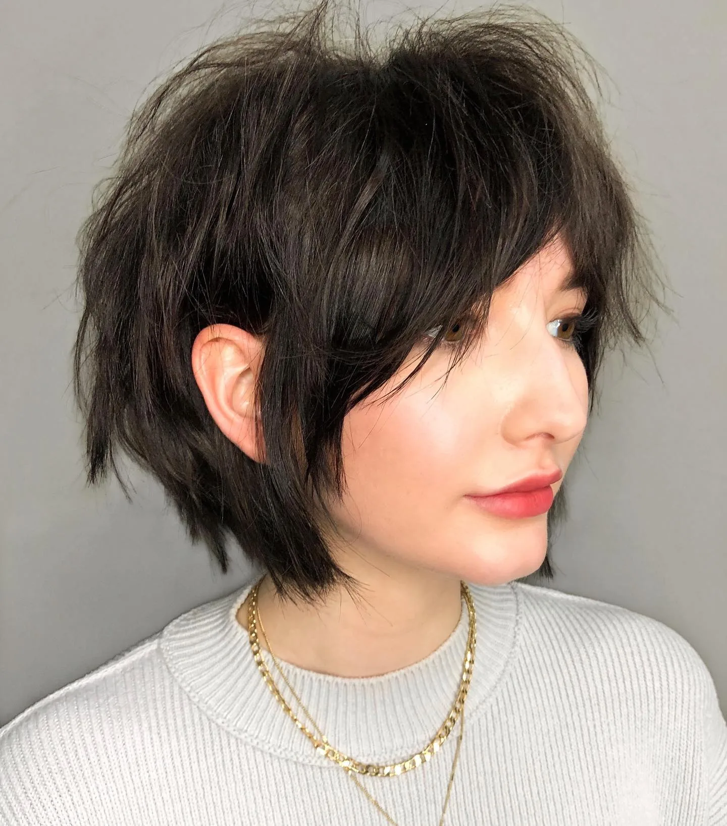 ear brunette pixie with side swept fringe shown as a shaggy pix mullet idea
