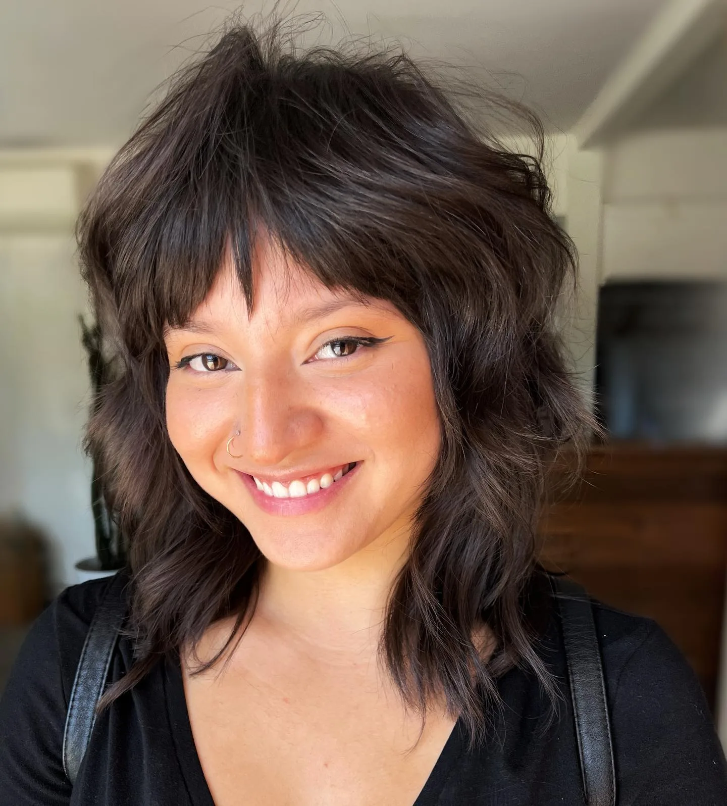 ear wavy brunette pixie with wispy fringe shown as a shaggy pix mullet idea