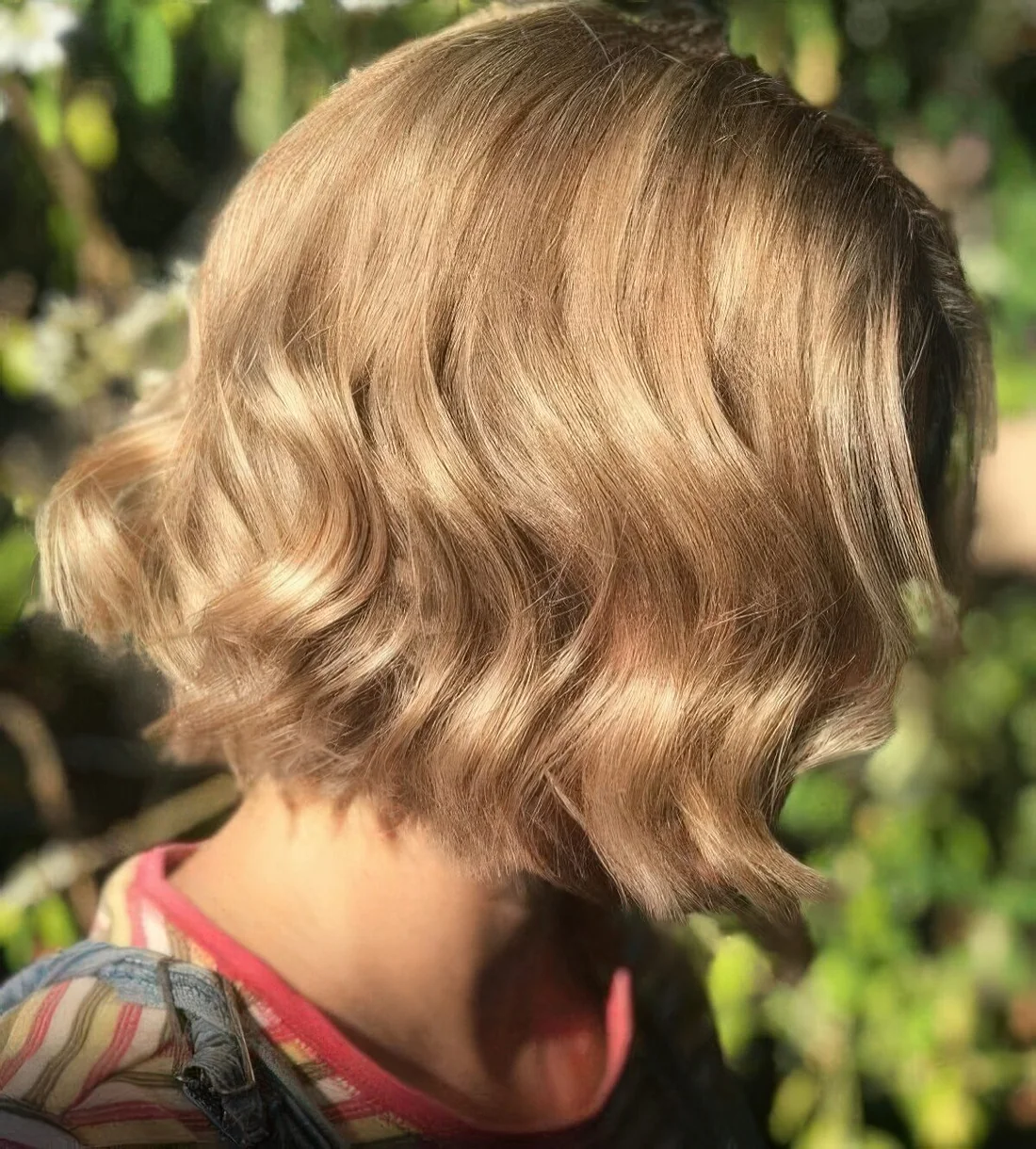 Honey blonde wavy bob with a shiny finish.