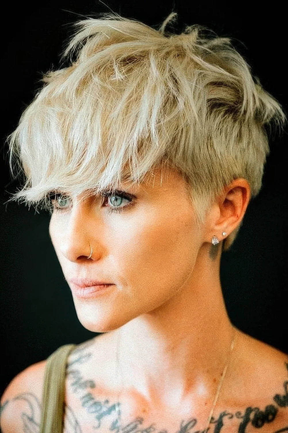 Blonde layered pixie with a longer top and front cut in layers and outgrown fringe.