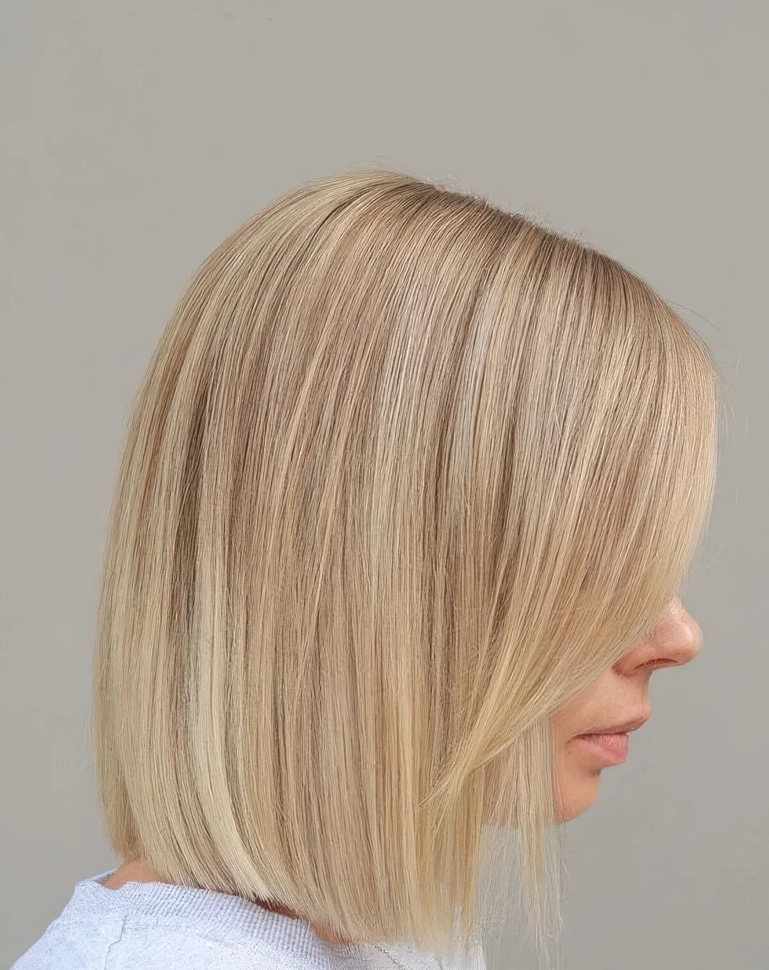 Photo showing blunt blonde bob with side bangs, with the hairstyle clearly visible.