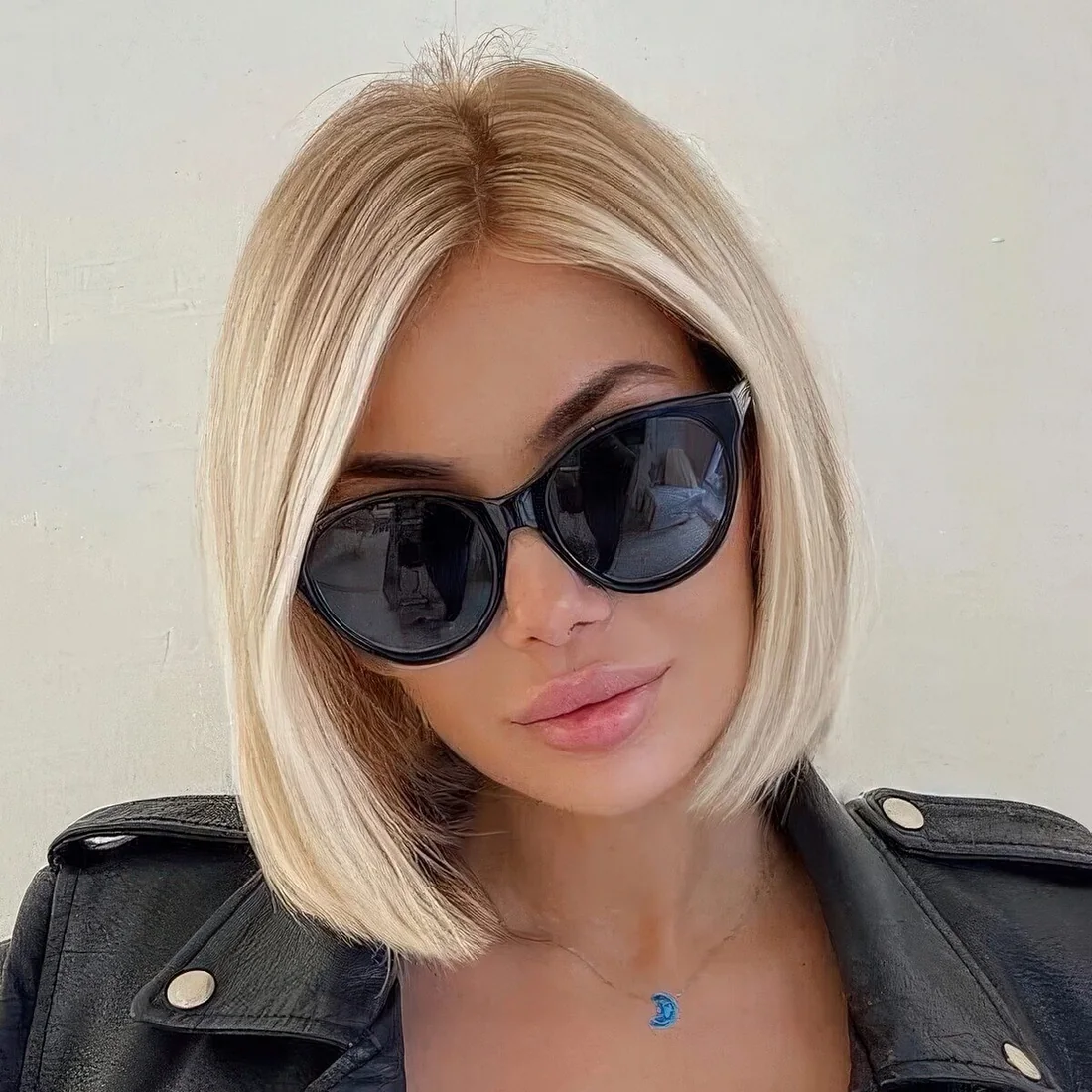 Classic chin-length creamy blonde bob with a lot of volume and side part.