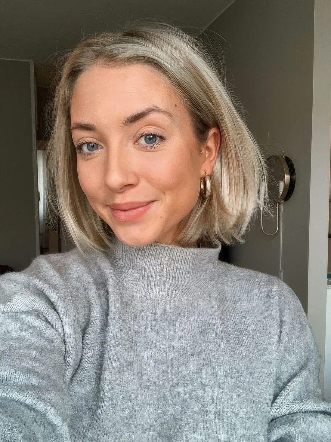 Long platinum bob with a messy part and curved ends.