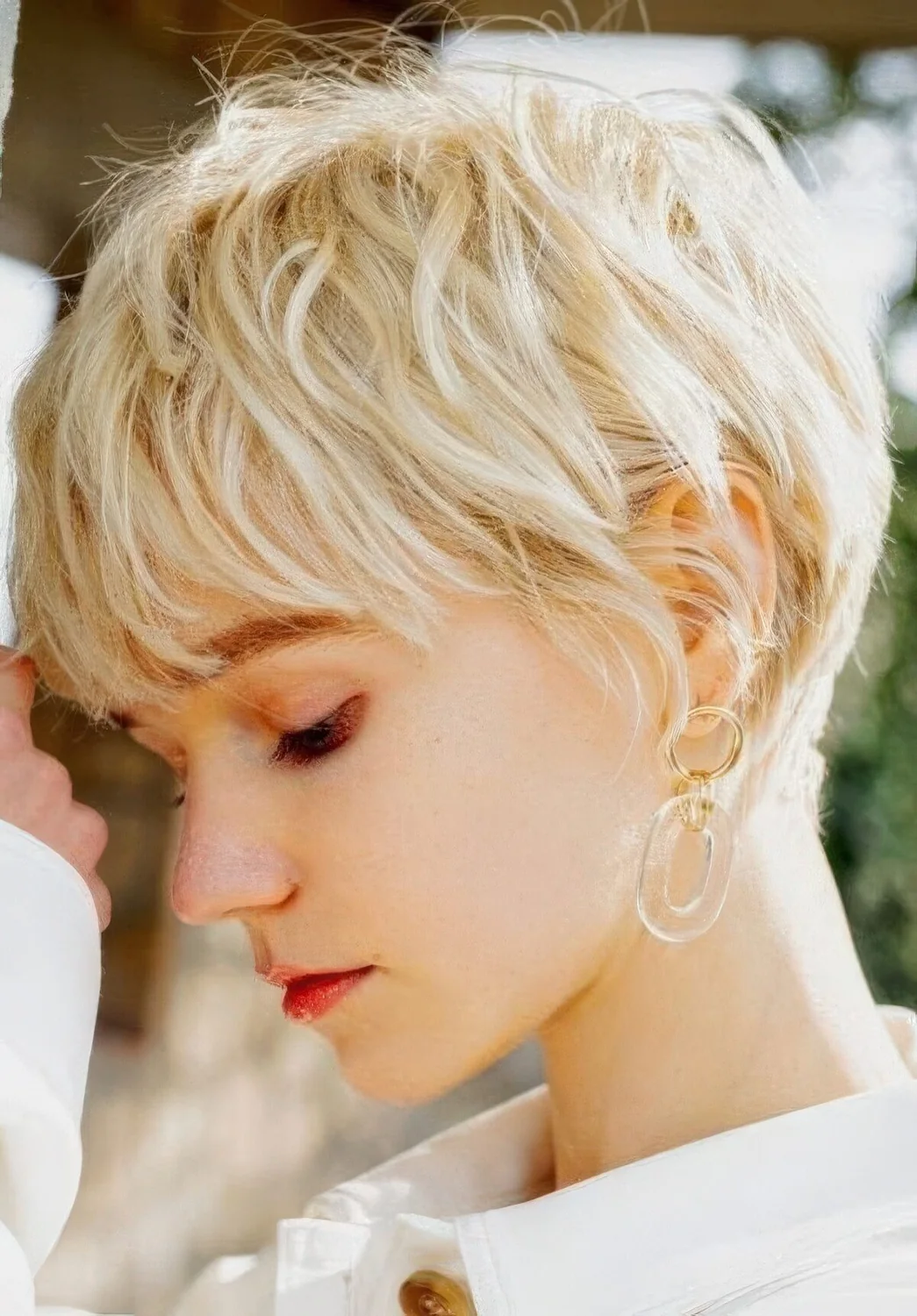 Messy creamy blonde layered pixie haircyt with feathered layers.