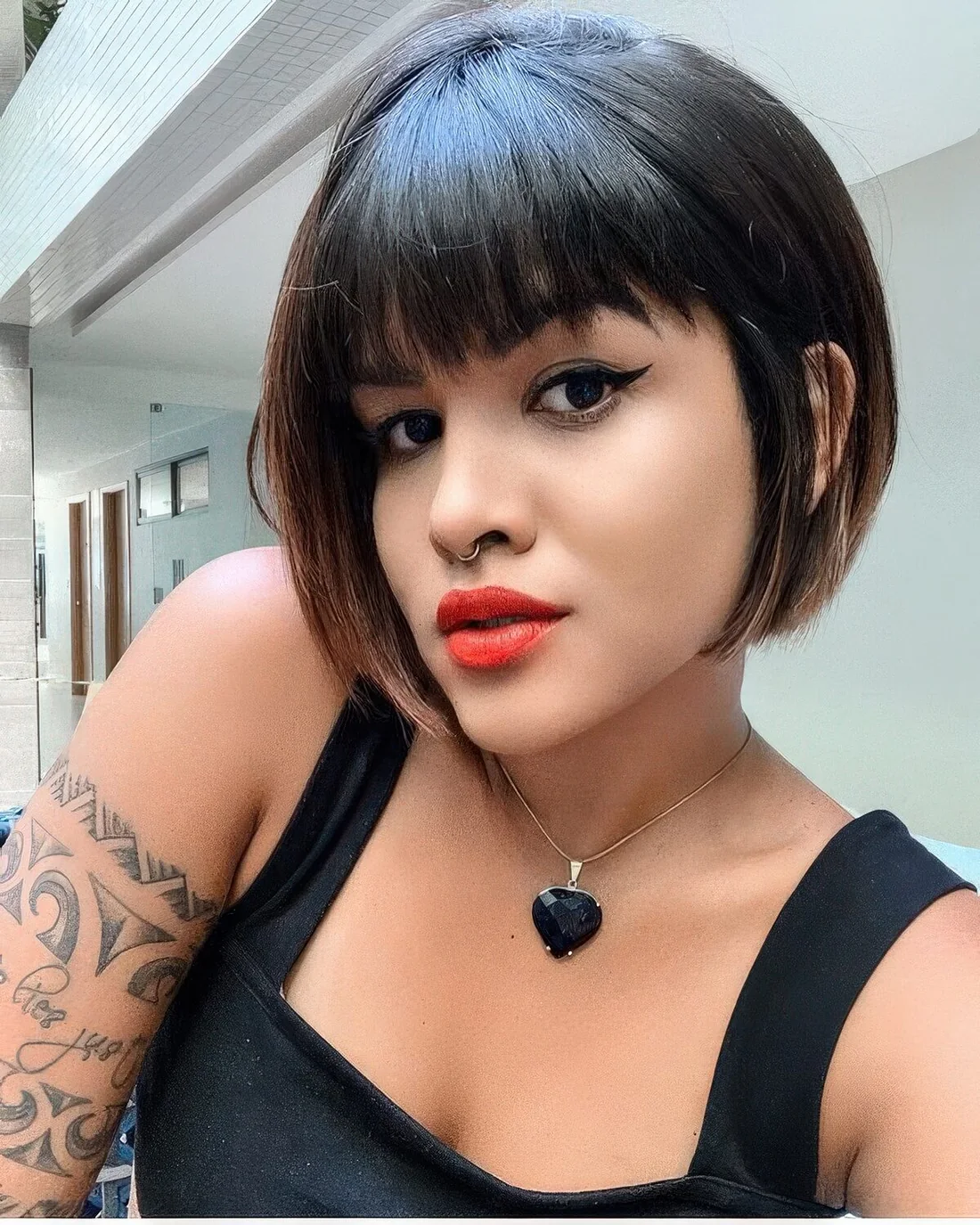 Black jaw-length bob with caramel balayage and blunt bangs.