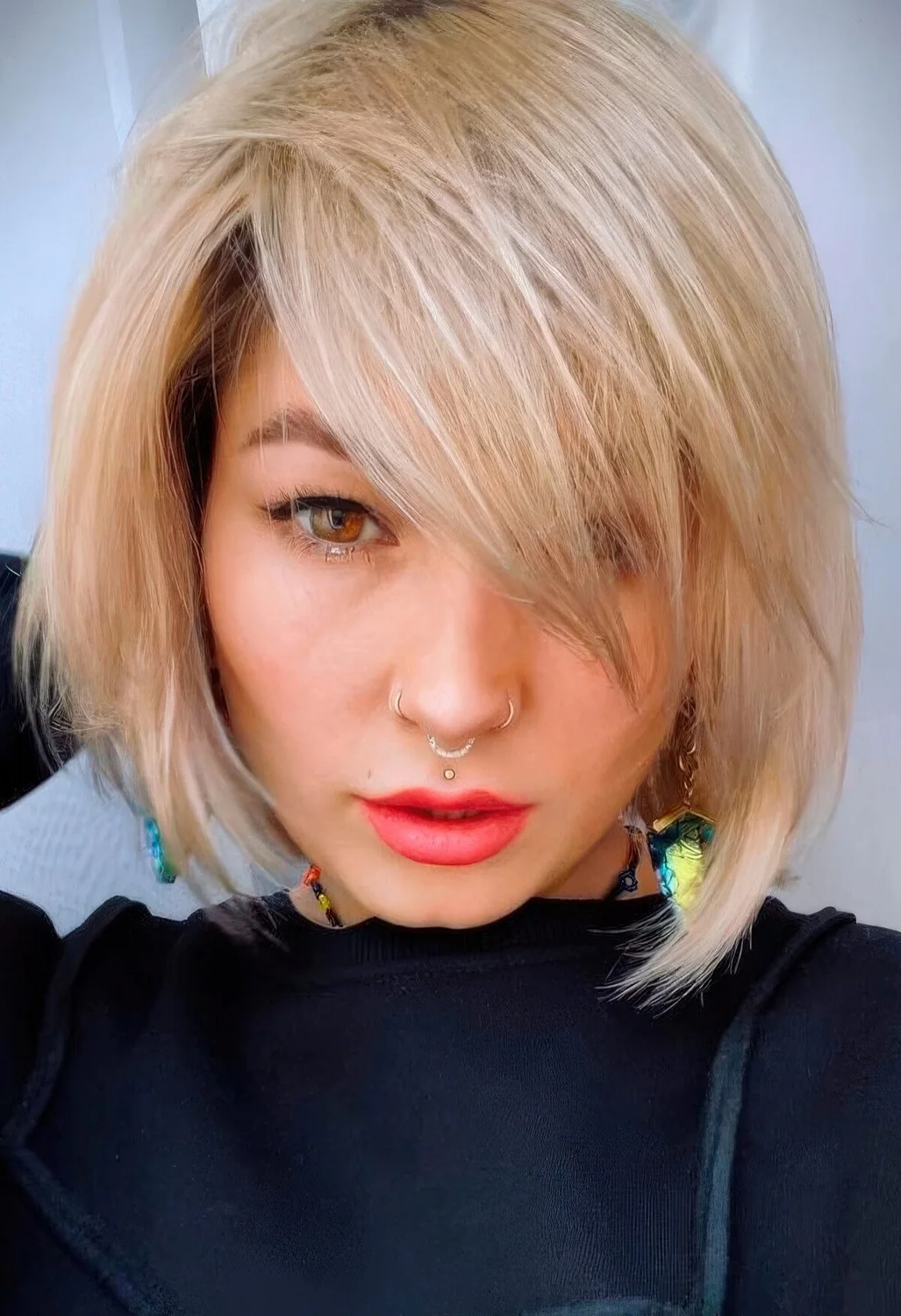Chin-length creamy blonde bob with side bangs and plenty of movement and texture.