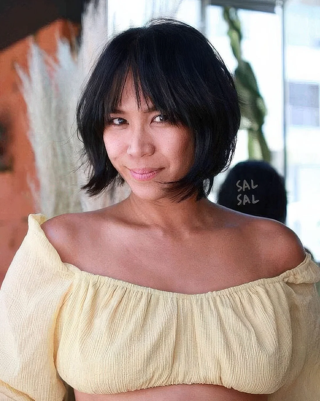 Black jaw-length bob with wispy and bottleneck bangs plus curved ends.