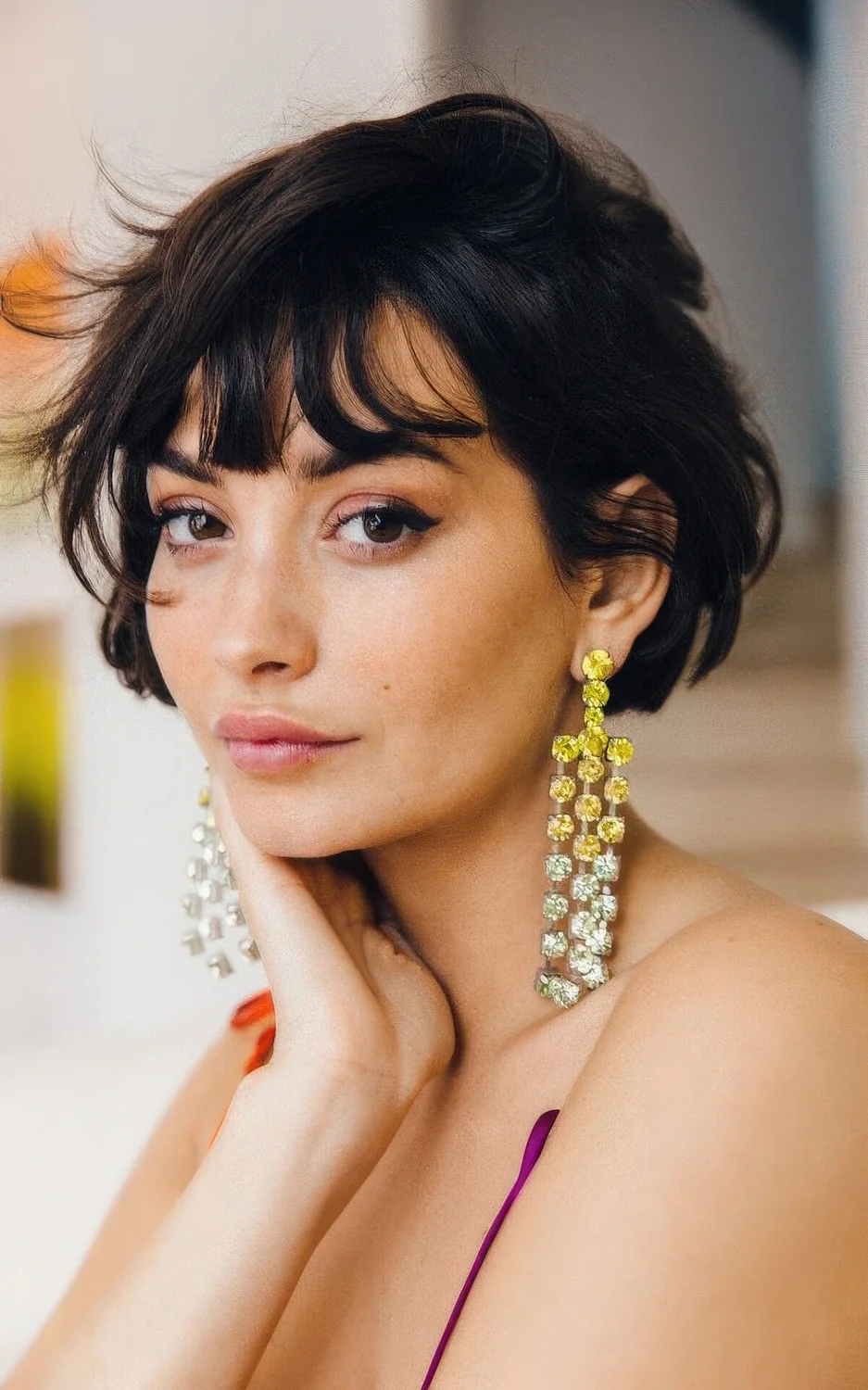 Black ear-length bob with wispy bangs and messy texture.