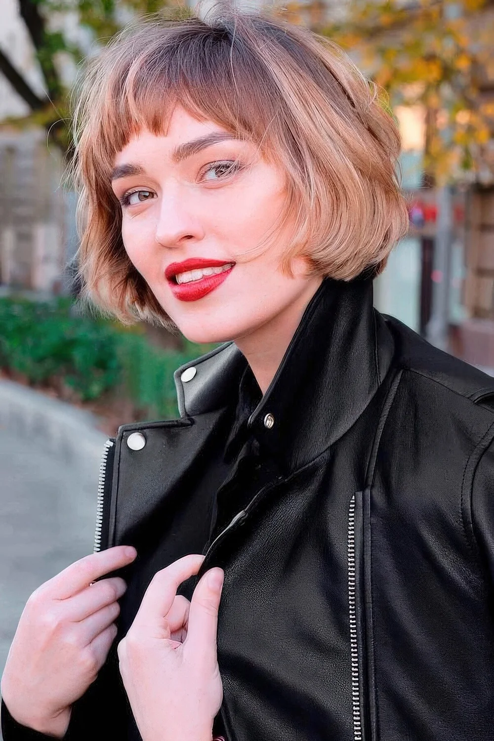Jaw-length brunette bob with blodne balayage and waves plus bangs.