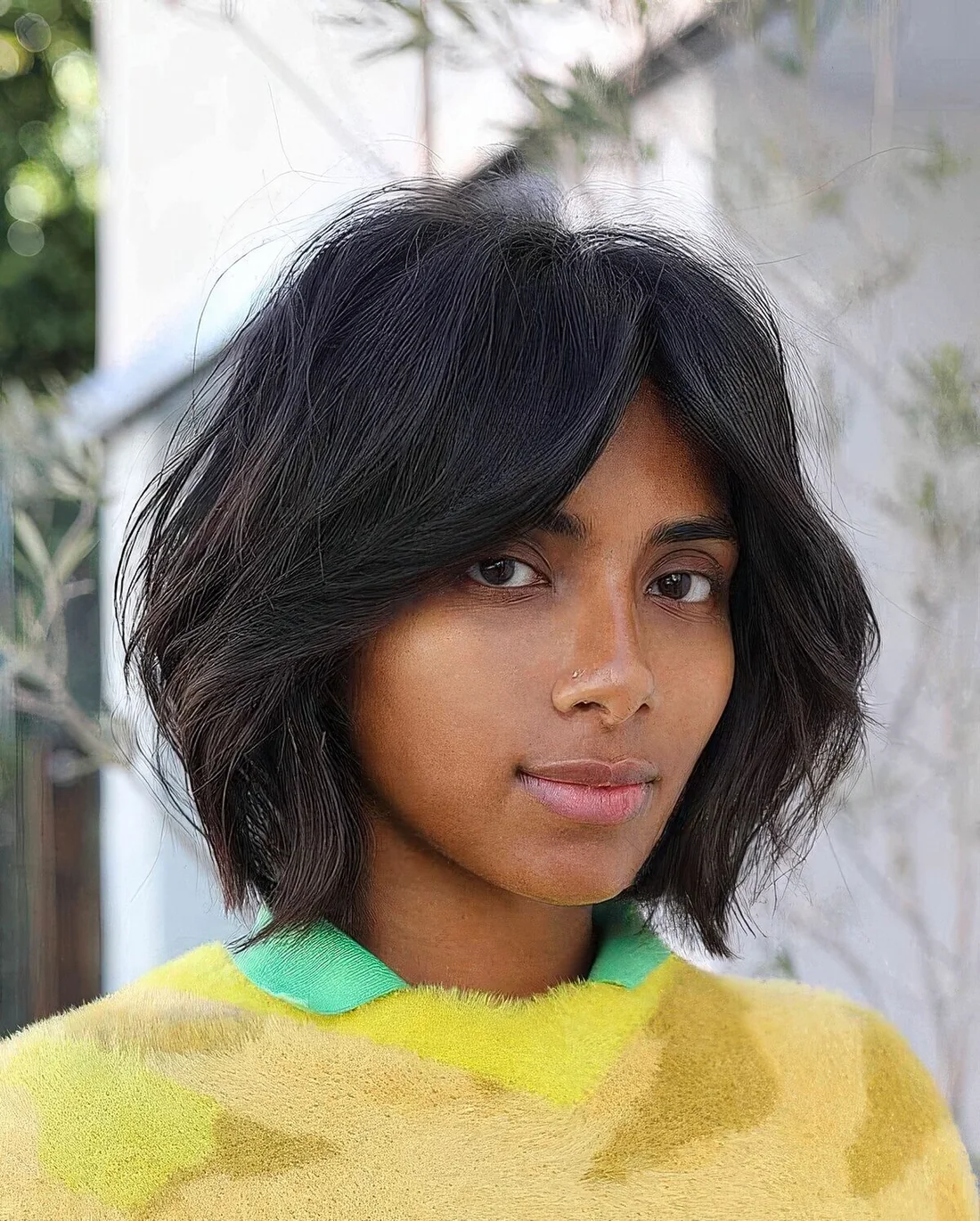 Black dimensional bob with bottleneck bangs and textured hair.
