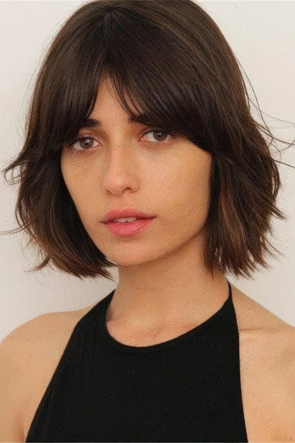 Dark brown bob with bottleneck bangs and textured shaggy hair.