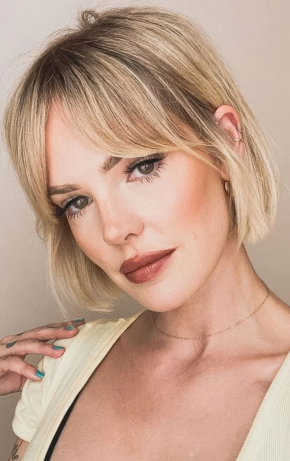 Blonde jaw-length bob with bottleneck bangs.