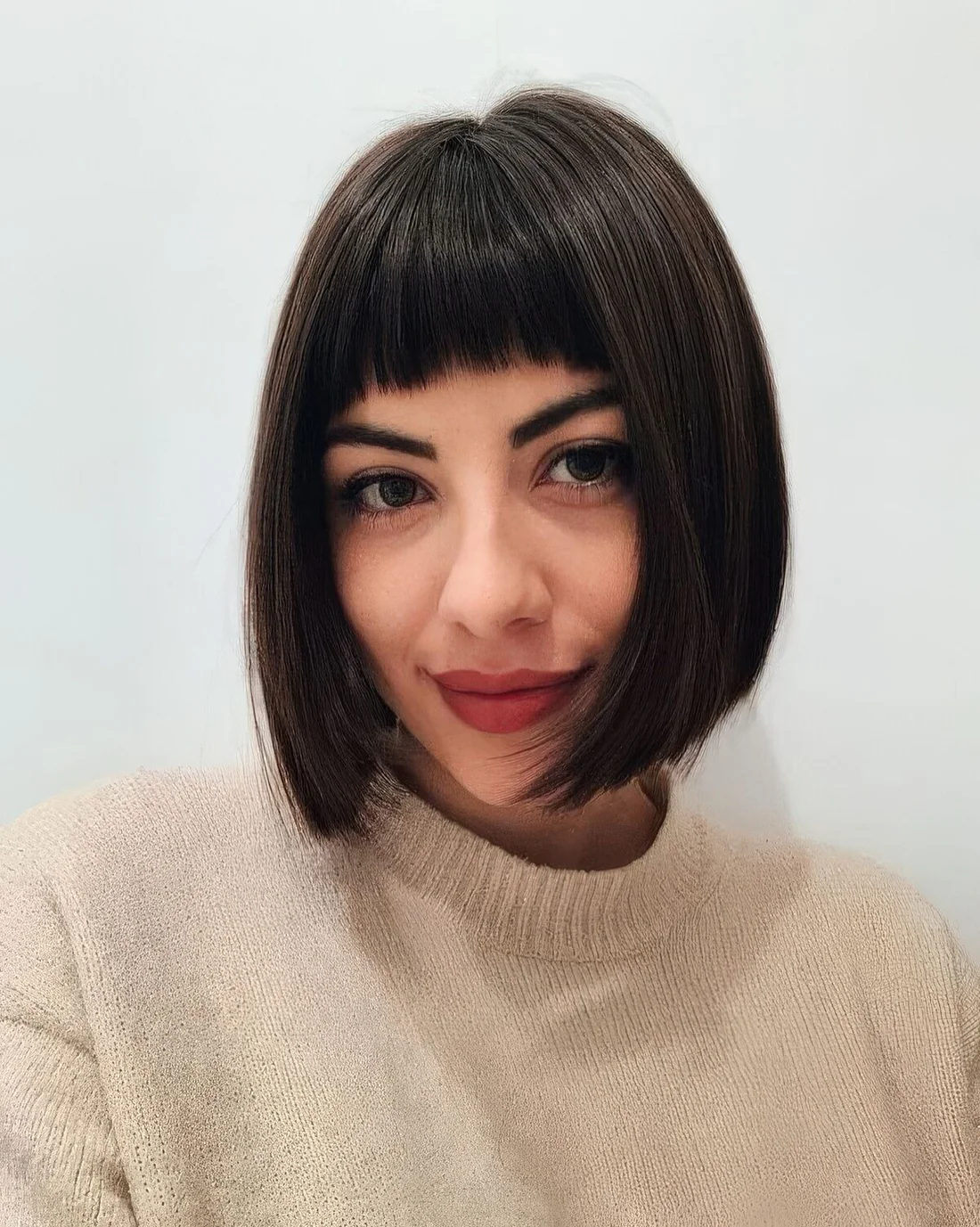 Photo showing sleek dark brown bob, with the hairstyle clearly visible.
