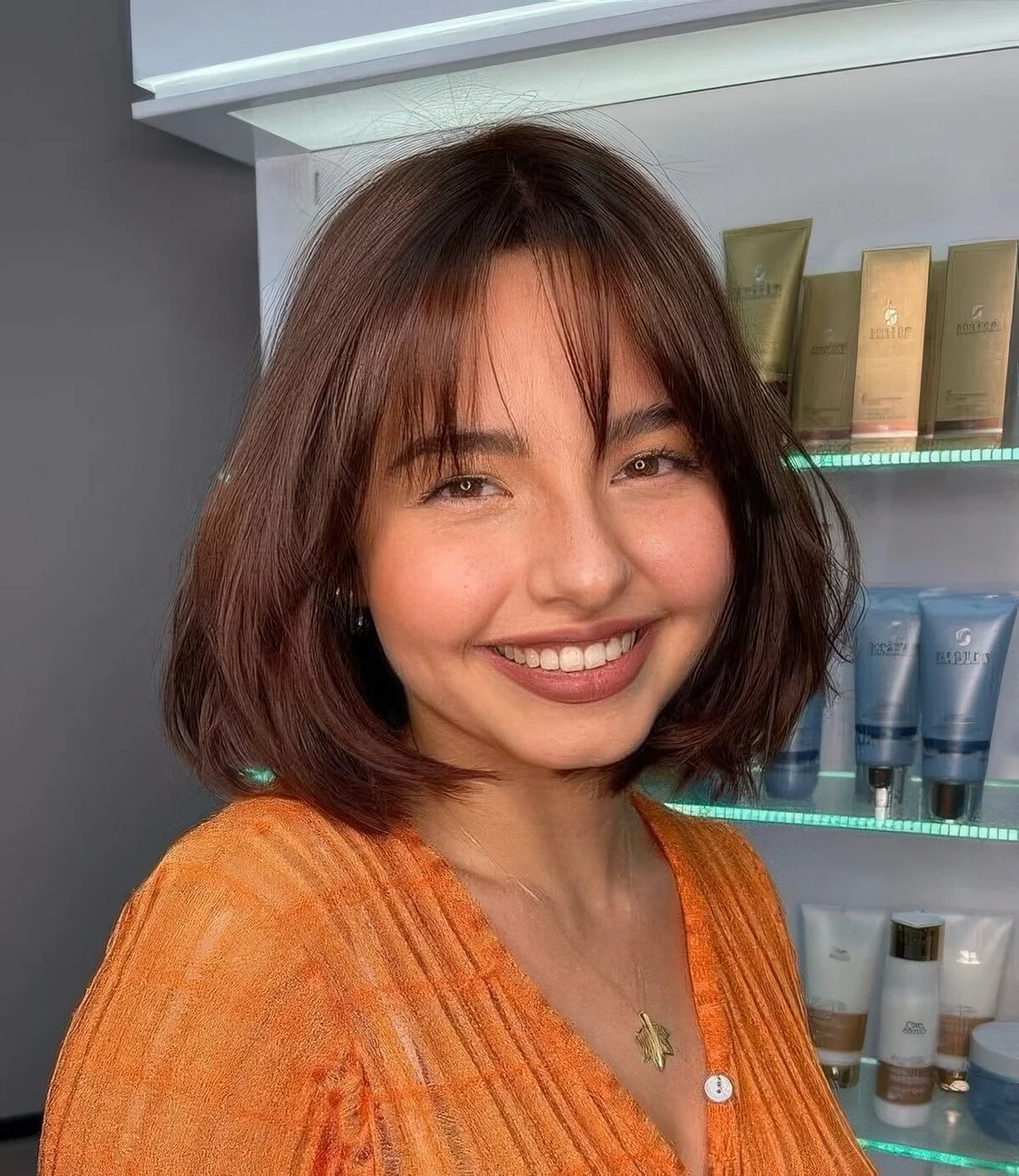 Burgundy rounded bob with wispy bangs.
