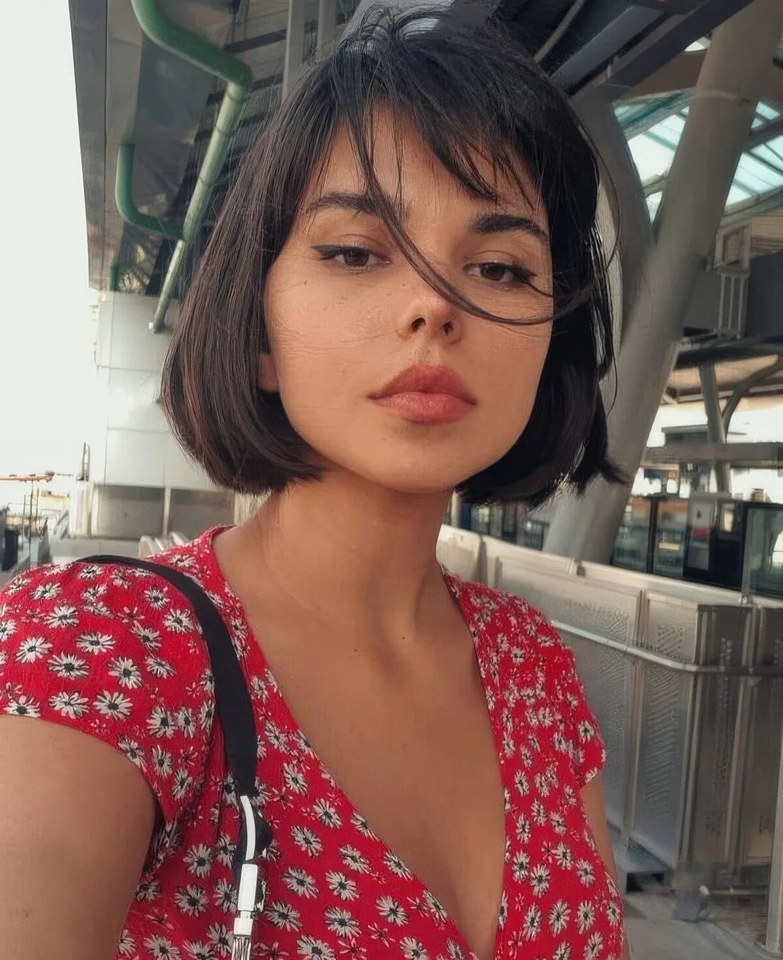 Dark brown chin-length bob with wispy bangs.