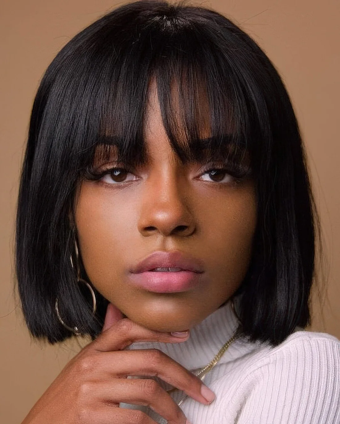 Short black bob with outgrown bangs.