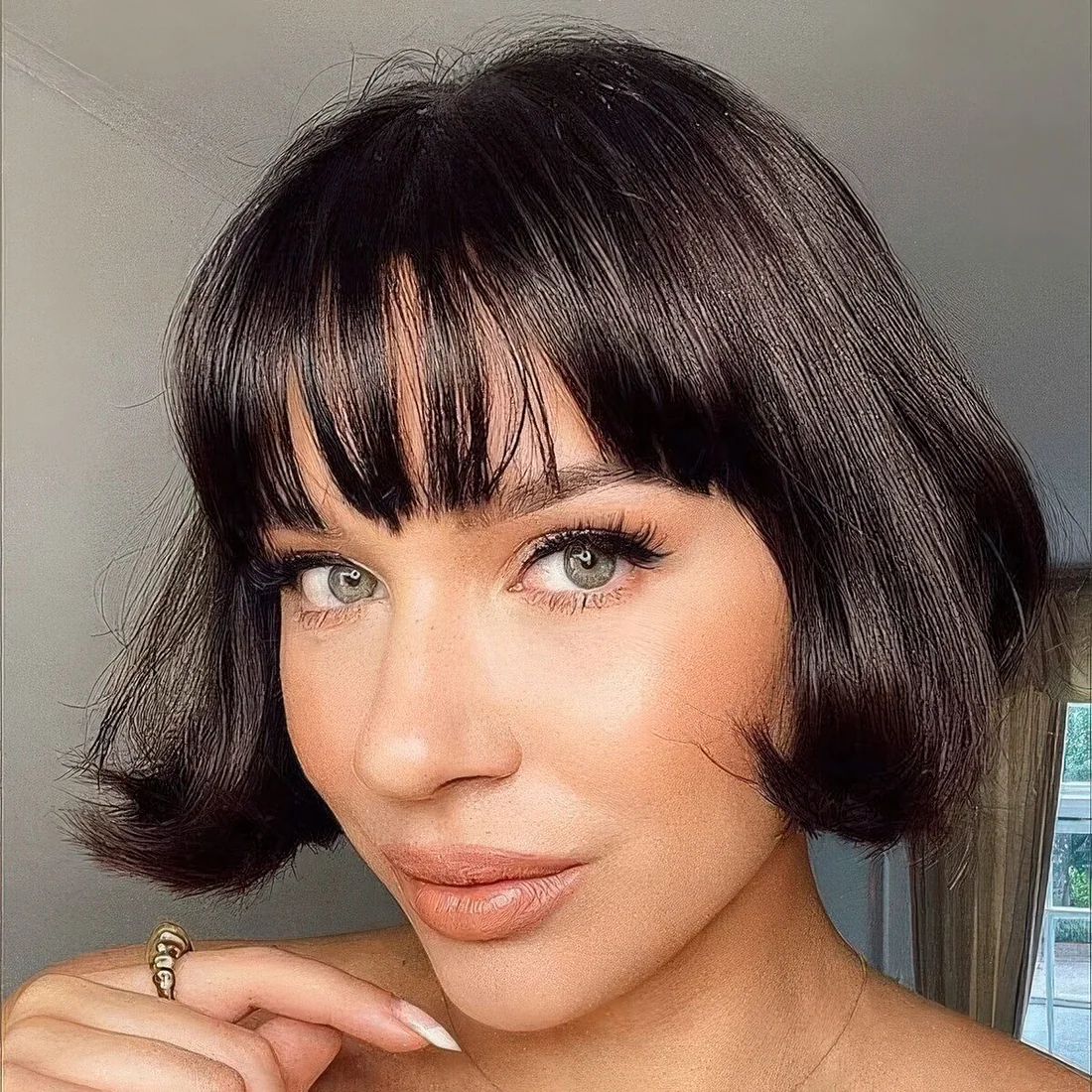 Short black bob with wispy bangs and curved ends.