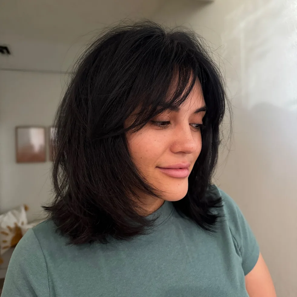 medium wavy black shag with side swept fringe shown as a short butterfly haircuts idea