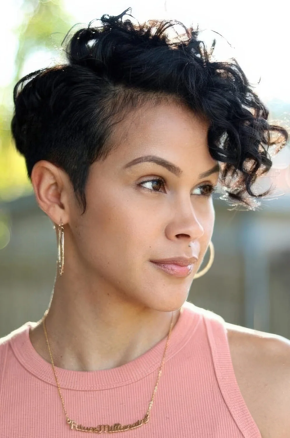 Photo showing black long curly pixie cut, with the hairstyle clearly visible.