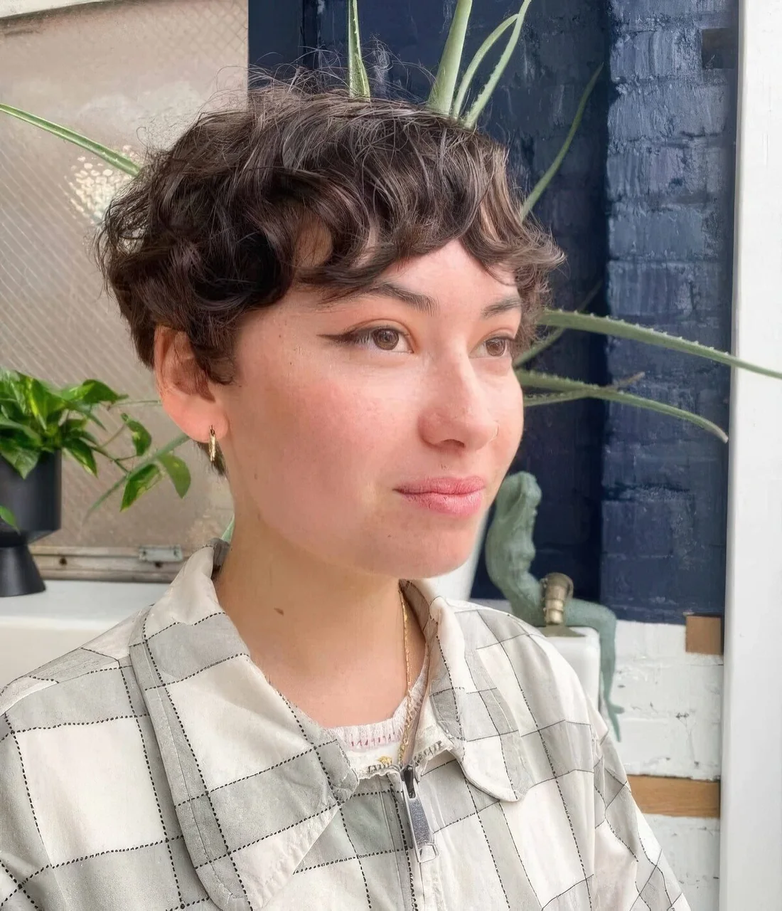 Photo showing brown wavy pixie with bangs, with the hairstyle clearly visible.