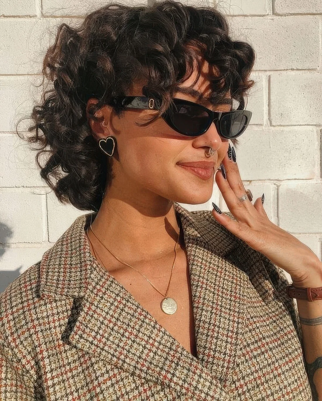 Dark brunette pixie mullet with long bangs.