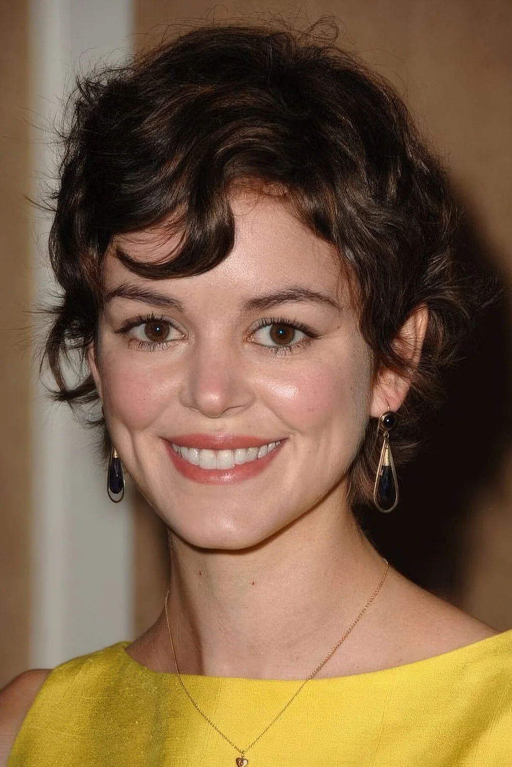 Messy brown wavy pixie with a bit of bangs.
