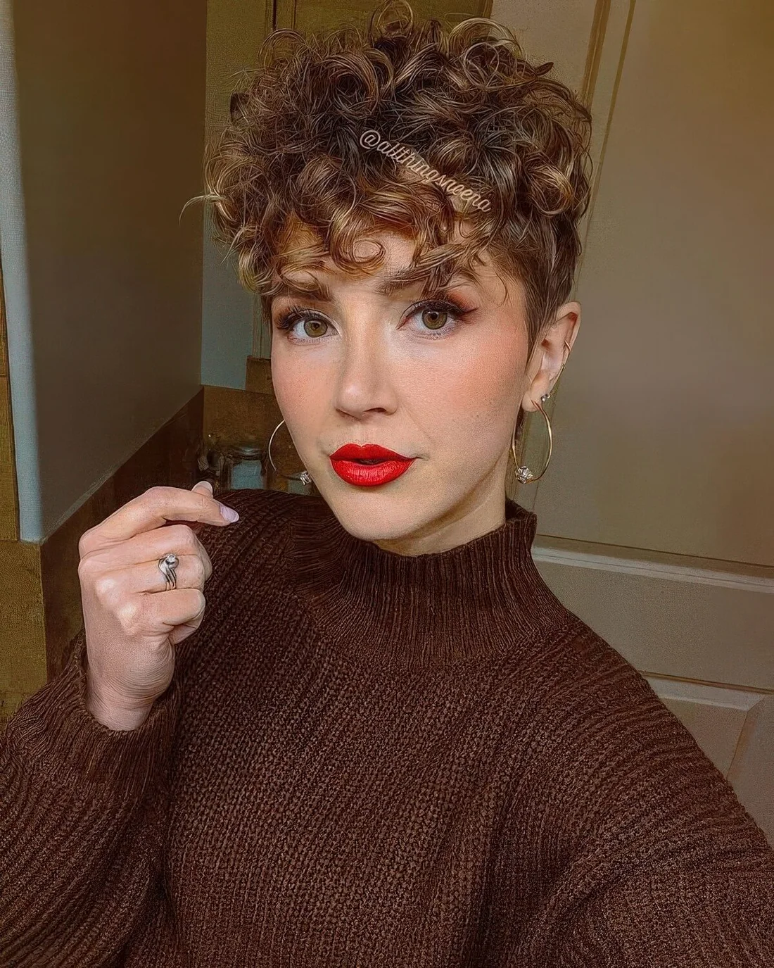 Light brunette curly pixie haircut with honey blonde balayage.