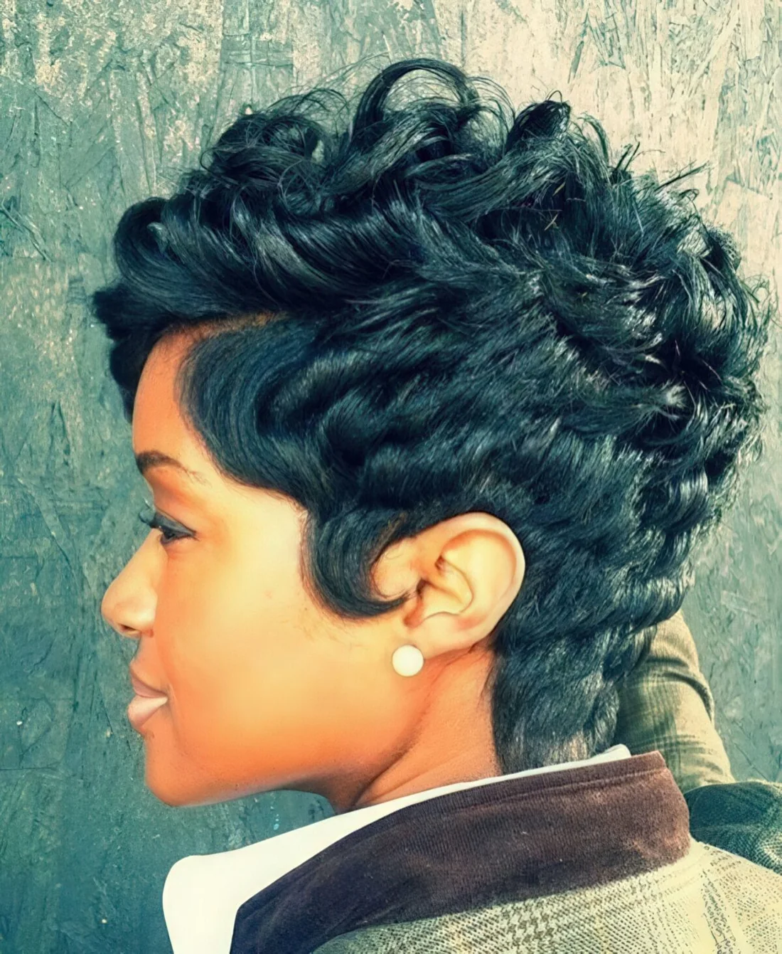 Chopped textured pixie haircut on curly hair.
