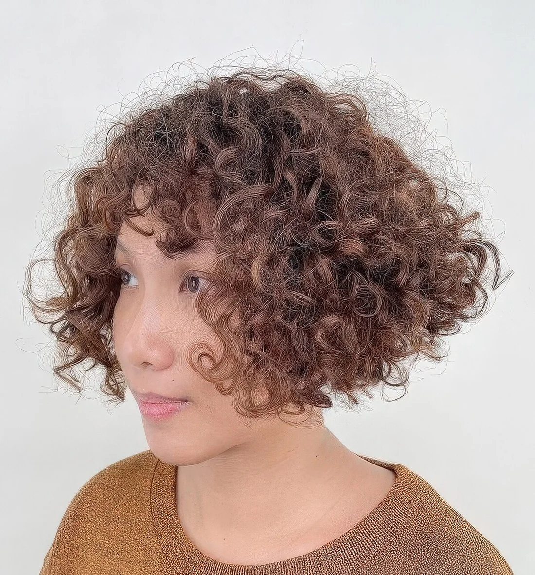 Curly inverted bob with short bangs.