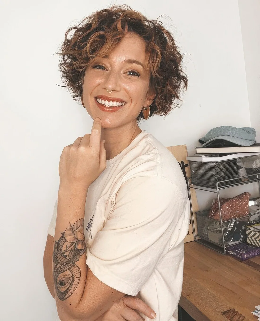 Jaw-length curly bob with copper balayage and a lot of volume.