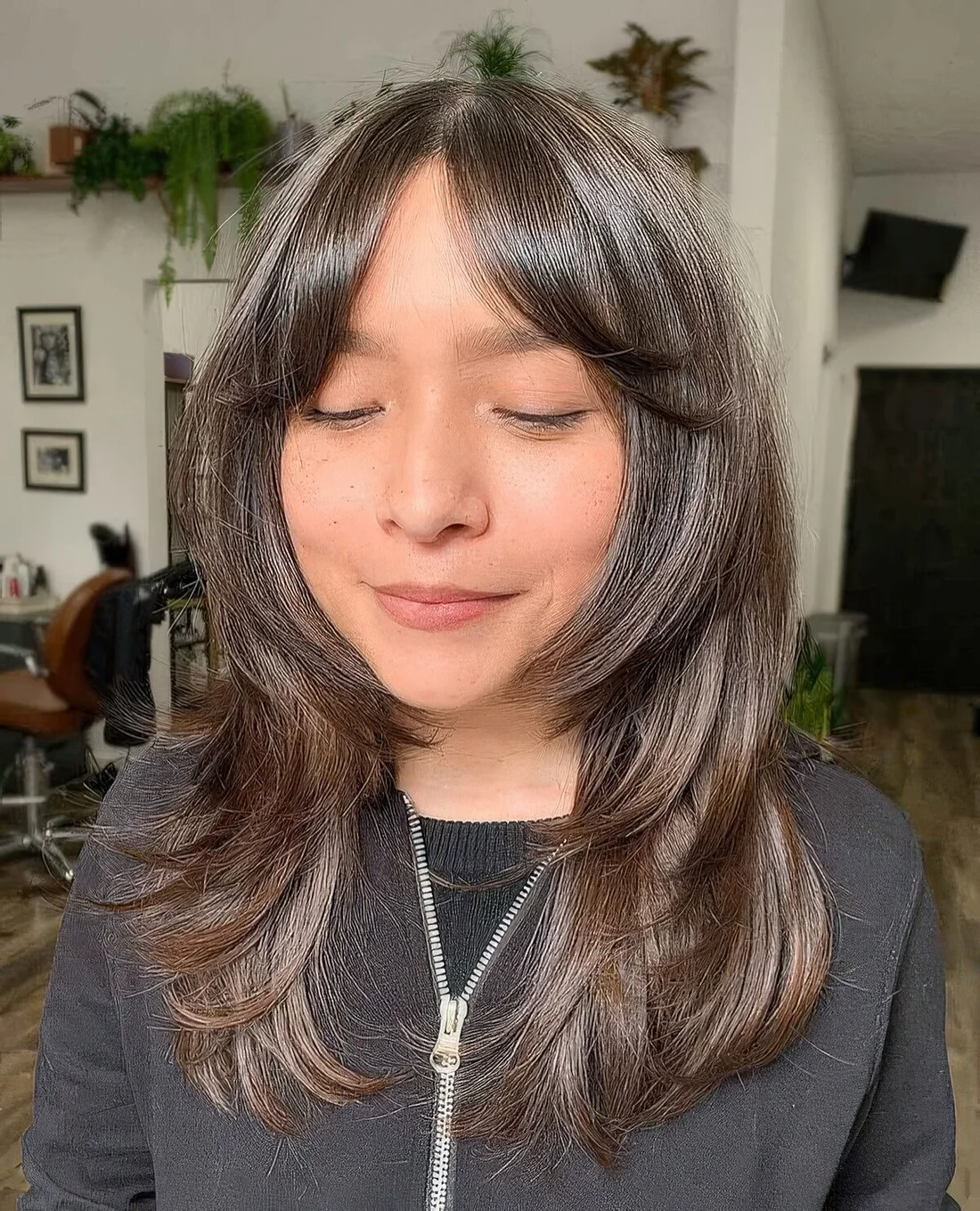 Chestnut brown butterfly haircut with short curtain bangs.