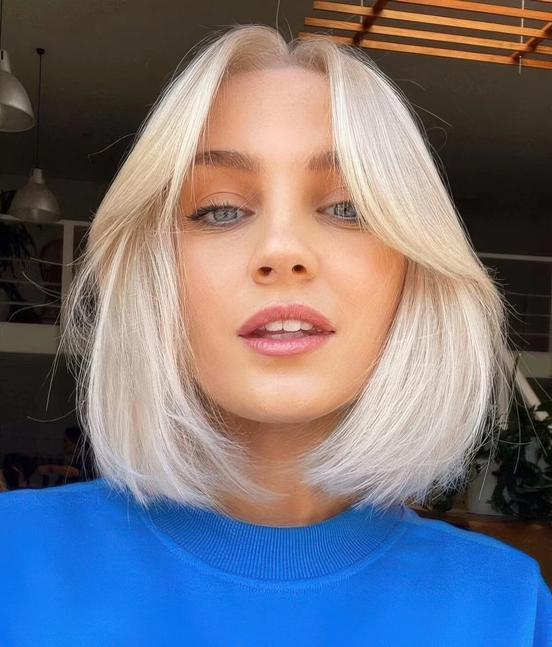 Icy blonde bob with short curtain bangs.